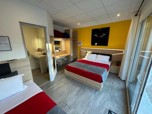 a hotel room with two beds and a desk at DOMAINE MAXXIM in Clermont-lʼHérault