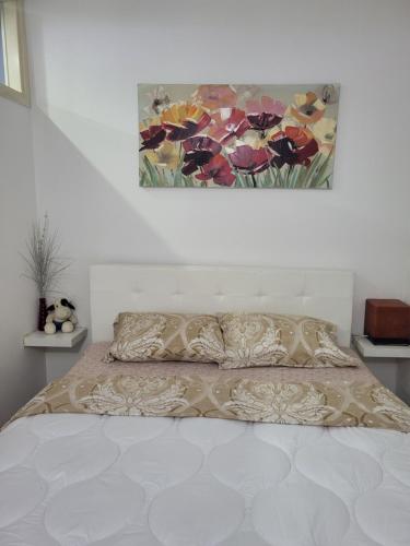 1 dormitorio con 1 cama con una pintura en la pared en Andjela, en Šabac