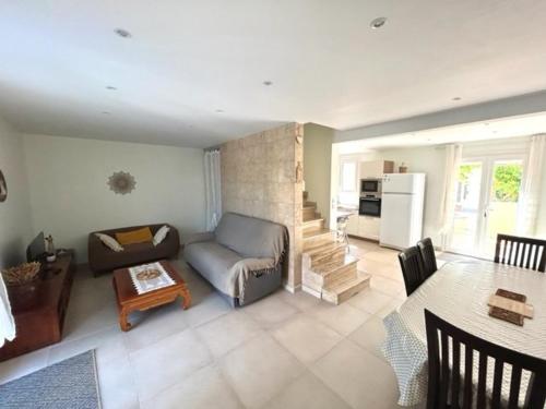 un salon avec un canapé et une table dans l'établissement Maison climatisée 5 pièces avec jardin privé et parking, proche gare et centre à Argelès-sur-Mer - FR-1-388-217, à Argelès-sur-Mer