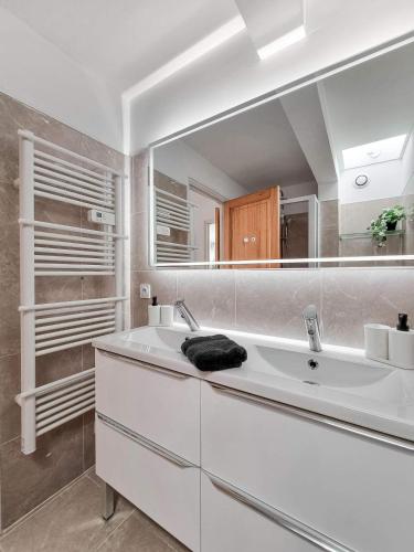 une salle de bain avec un lavabo et un grand miroir dans l'établissement Le Coucher de Soleil, à La Seyne-sur-Mer