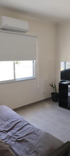 a white room with a bed and a window at Los alamos in San Miguel del Monte