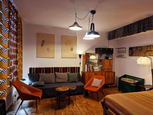 a living room with a couch and a table and chairs at STUDIO KLIMAT PRAGA in Warsaw