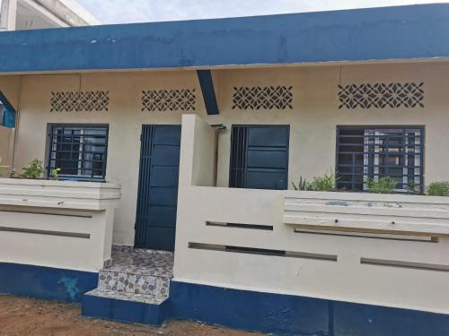 een huis met blauwe deuren en ramen bij PROSPERITY in Sambava