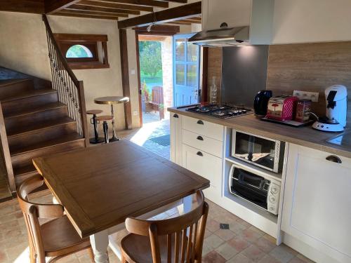 - une cuisine avec une table en bois et une cuisinière four supérieur dans l'établissement Gîte de charme au bord de l'eau, à 30min du Mans, cadre paisible avec pêche et randonnées à proximité - FR-1-410-414, à Congé-sur-Orne