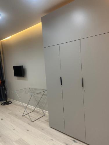 een grote witte kast in een kamer met een televisie bij Good Home на 8 персон in Alma-Ata