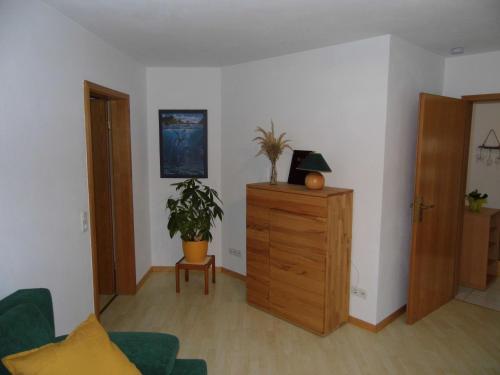 sala de estar con tocador de madera y planta en Ferienwohnung Hof 22, en Hilchenbach