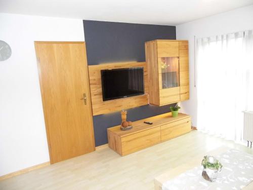 a living room with a tv and a wooden cabinet at Ferienwohnung Hof 22 in Hilchenbach