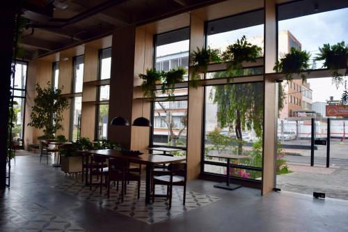 a restaurant with tables and chairs and large windows at Chic downtown loft - near Zona Rosa in Bogotá
