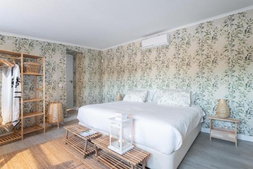 a bedroom with a bed and floral wallpaper at Casal da serra da Arrábida in Palmela