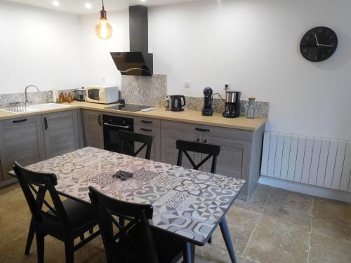 a kitchen with a table with chairs and a counter top at Charmant Gîte Familial à Gilley, Proche Fayl-Billot et Cite Fortifiée de Langres - FR-1-611-71 in Gilley