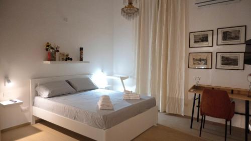 Habitación blanca con cama y escritorio en Giachery House Palermo, 4 min. dalla stazione Giachery en Palermo