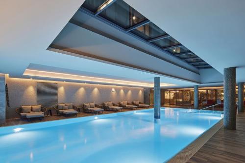 a swimming pool in a building with couches and chairs at TITANIC Chaussee Berlin in Berlin