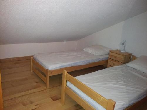 Cette chambre comprend 2 lits jumeaux et du parquet. dans l'établissement Appartement cosy 5 pers avec balcon sud à l’Alpe d’Huez, skis aux pieds - FR-1-405-28, à L'Alpe-d'Huez