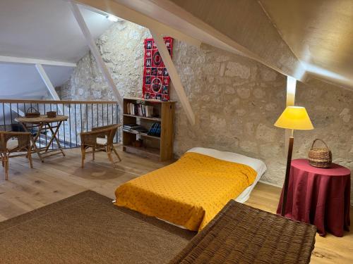 een slaapkamer met een bed en een tafel met een lamp bij Gite Les Hortalis in Monjoi
