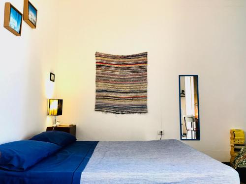 1 dormitorio con 1 cama y 1 manta en la pared en Casa Matilda, en Berchidda