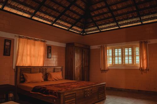 a bedroom with a bed in a room with windows at LEXI MEADOWS in Virajpet