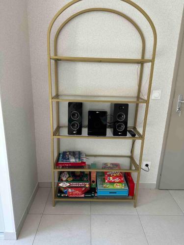 Une étagère avec trois haut-parleurs et quelques plats dans l'établissement Le meublé d Emma, à Saint-Jean-de-Monts