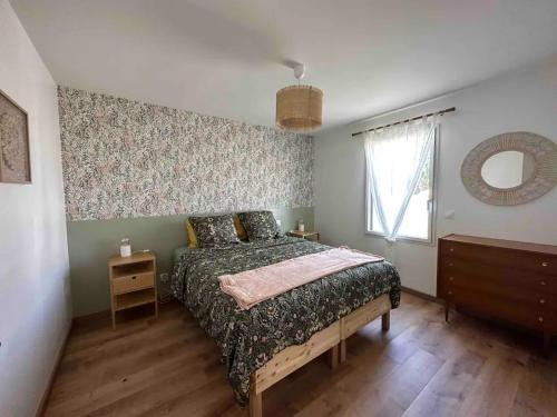 une chambre avec un lit, une commode et un miroir dans l'établissement Le meublé d Emma, à Saint-Jean-de-Monts