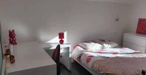 une petite chambre avec un lit et un bureau dans l'établissement Le 135, logement spacieux entre ville et volcans, à Ceyrat