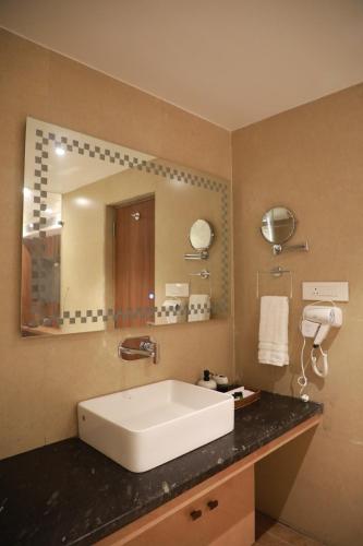 a bathroom with a sink and a large mirror at HOTEL RAMTA CONTINENTAL in Patna