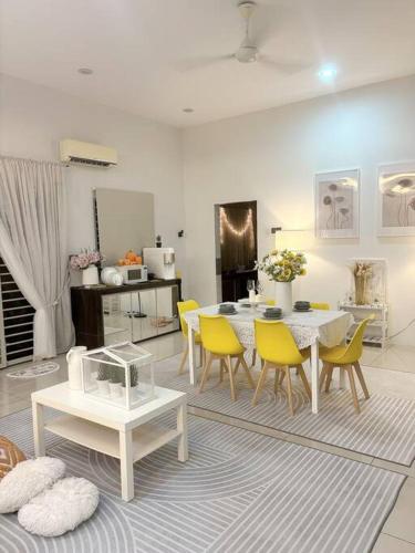 a living room with a table and yellow chairs at Homestay taiping in Taiping