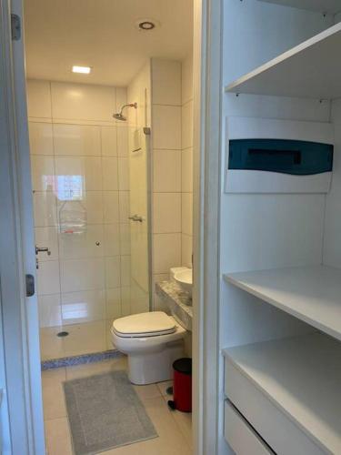 a white bathroom with a toilet and a shower at Flat Premium Recife - Ilha do leite piscina termica in Recife