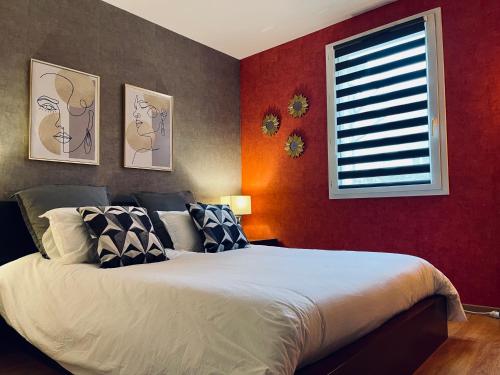 - une chambre avec un lit aux murs rouges et une fenêtre dans l'établissement Appart’ calme - 48m² - proche Versailles - Paris, à Élancourt