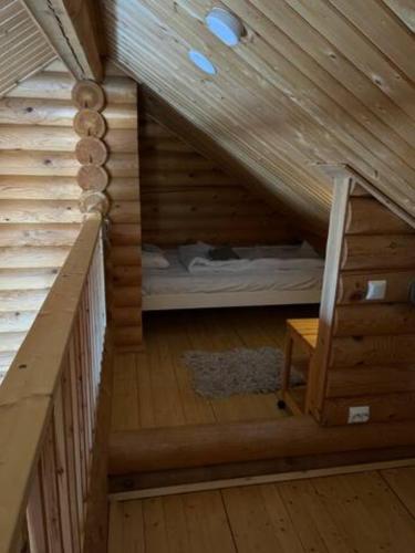 a room with a bed in a wooden attic at Villa Kalajärvi in Seinäjoki