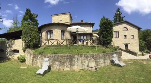 una casa con una pared de piedra delante de ella en Locanda La Posta, en Castel dʼAiano