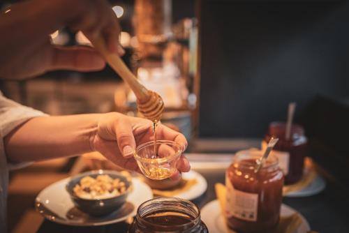 a person holding a bowl of food with a spoon at Le Forges Hotel in Forges-les-Eaux