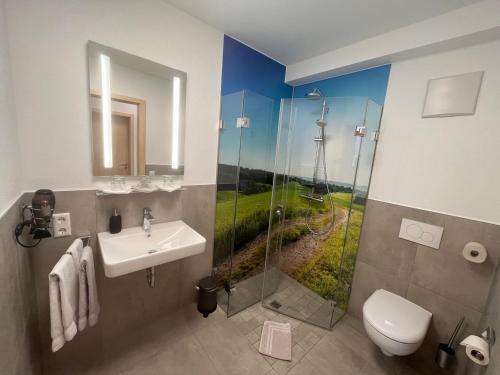 een badkamer met een wastafel en een douche met een foto bij Gaestehaus Zum Wolffenturm 