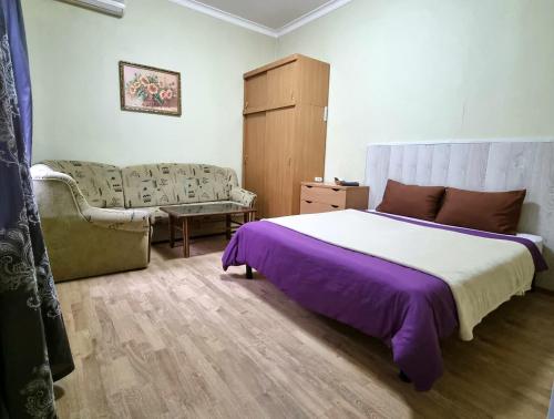 a bedroom with a large bed and a couch at ARTAPARTMENTS-center in Chernihiv