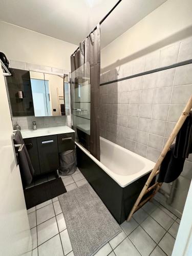 une salle de bain avec une baignoire et un lavabo dans l'établissement Appart’ calme - 48m² - proche Versailles - Paris, à Élancourt