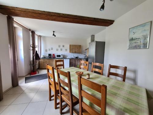a kitchen and dining room with a table and chairs at Gîte familial en ferme avec jardin, proche forêt et canal d'Orléans - Label Tourisme et Handicap - FR-1-590-7 in Chailly-en-Gâtinais