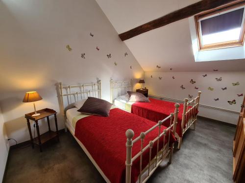 - 2 lits dans une chambre avec des draps rouges et des papillons sur le mur dans l'établissement Gîte Chailly-en-Gâtinais, 5 pièces, 8 personnes - FR-1-590-7, à Chailly-en-Gâtinais