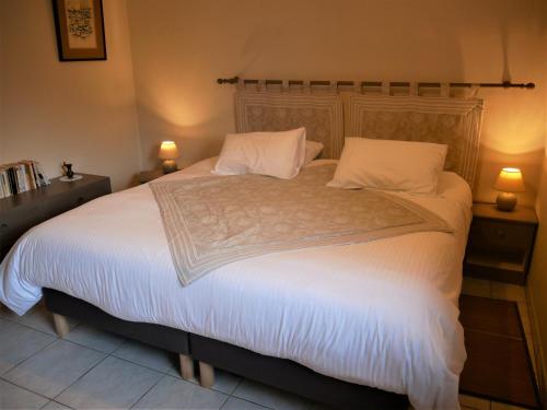 een slaapkamer met een groot bed met witte lakens en kussens bij Gîte Guilly, 2 pièces, 2 personnes - FR-1-590-30 in Guilly