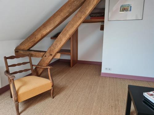 a wooden chair sitting in a room with a ladder at Charmant gîte rénové avec jardin, proche du Val de Loire et du Sancerrois, idéal pour familles - FR-1-590-33 in Beaulieu-sur-Loire