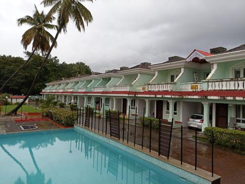une maison avec une piscine en face de celle-ci dans l'établissement Mint Villa, Benaulim, Goa, à Benaulim