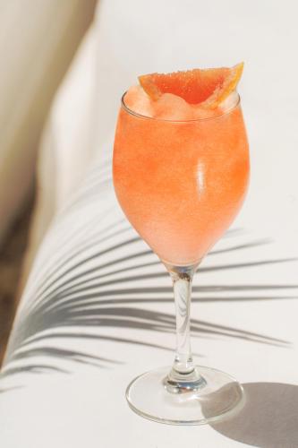 a drink in a glass with a piece of fruit in it at Nammos Hotel Mykonos in Psarou