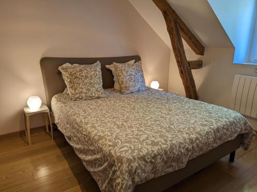 Una cama en una habitación con dos lámparas. en Gîte Audeville, 5 pièces, 8 personnes - FR-1-590-136 en Audeville