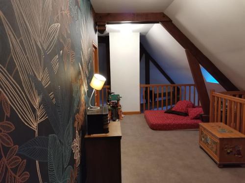 a attic room with a staircase and a red couch at Gîte Bénaménil, 5 pièces, 6 personnes - FR-1-584-4 