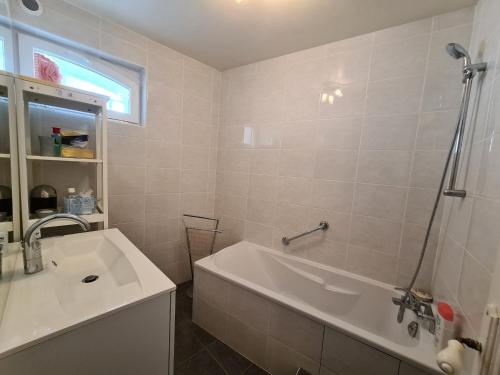 a bathroom with a bath tub and a sink at Gîte spacieux au cœur du Val de Loire, entre Orléans et Blois, avec jardin, cour fermée et BBQ ! - FR-1-590-106 in Tavers