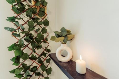 a white vase and a candle on a shelf at 2 Bedroom Peaceful Home, Colchester in Mile End