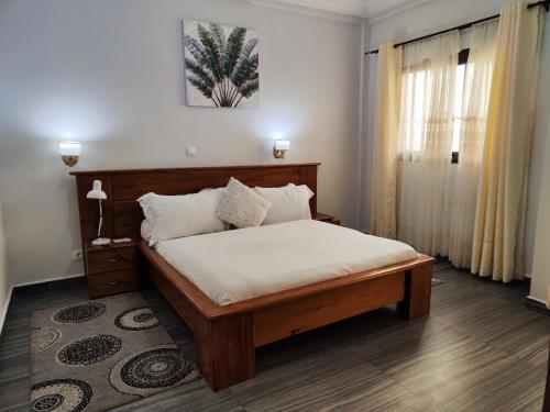 HOTEL DE L'OCEAN KRIBI في كريبي: غرفة نوم بسرير ذو شراشف بيضاء