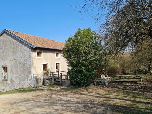 an old stone building with a tree in front of it at Gîte chaleureux au bord d'un ruisseau avec grand jardin, proche Metz et Nancy - FR-1-584-64 in Vandières