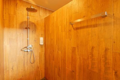 y baño con ducha en una pared de madera. en Gu Hotel Patong, en Patong Beach