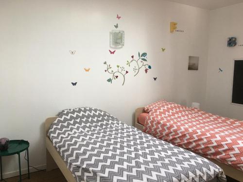2 Betten in einem Zimmer mit Schmetterlingen an der Wand in der Unterkunft Gîte Athienville, 6 pièces, 12 personnes - FR-1-584-84 in Athienville