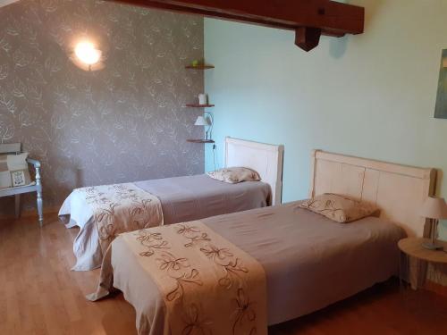 - une chambre avec 2 lits et un mur orné d'un pochoir mural dans l'établissement Gîte familial calme avec jardin, wifi et équipements bébé, animaux acceptés - FR-1-584-92, à Saint-Germain