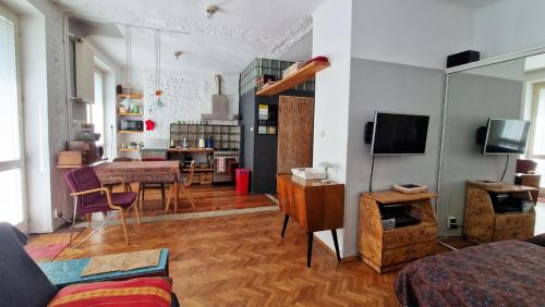 a living room with a couch and a dining room at Studio Klimat MOKOTÓW in Warsaw