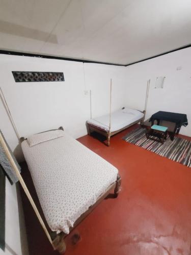 a room with two beds and a piano at The Blues in Alleppey
